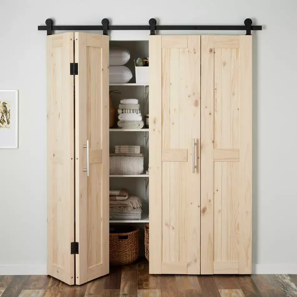 Natural wood bi-fold barn doors partially open in front of organized closet shelving