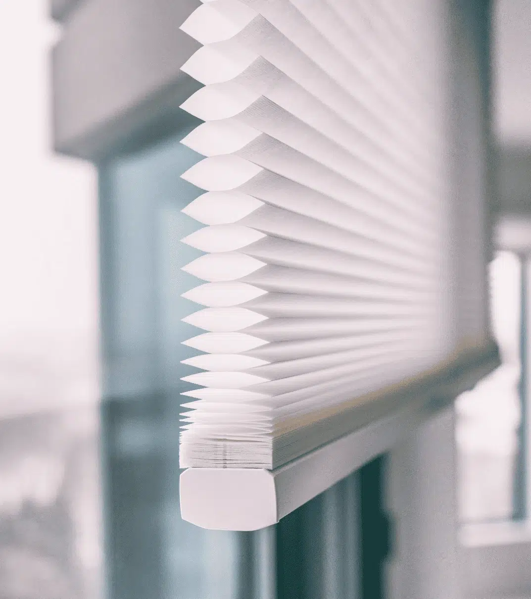 Close-up of the pleated honeycomb structure of a white cellular shade