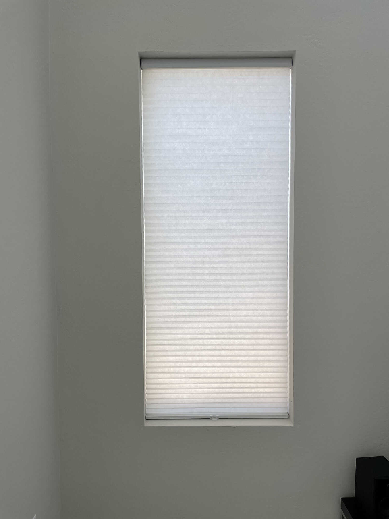 White cellular shade lowered over a residential window