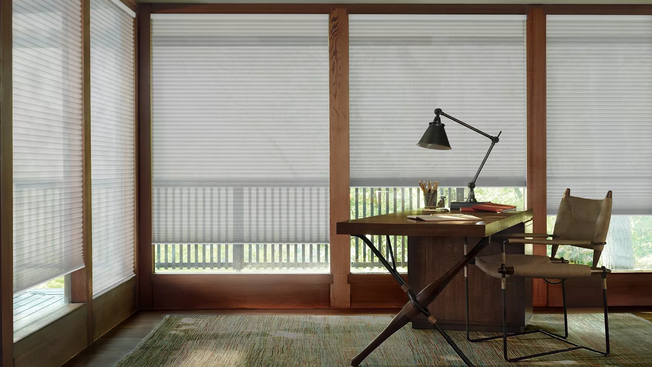 White cellular shades filtering light in a home office