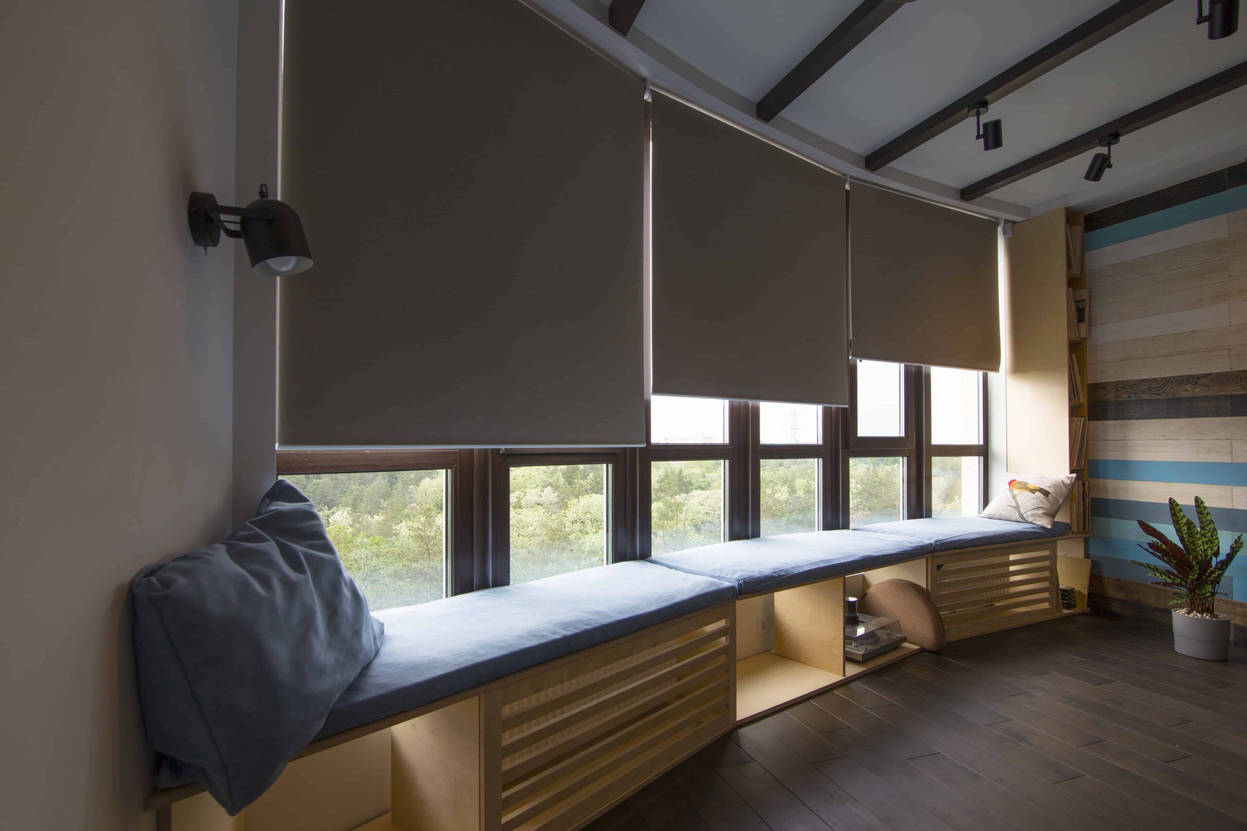 Charcoal roller shades above a built-in window bench