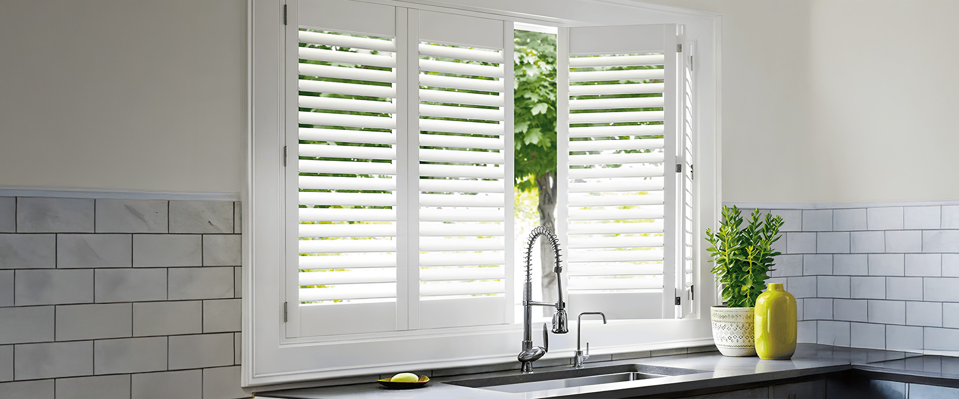 White plantation shutters fitted to a kitchen window above the counter
