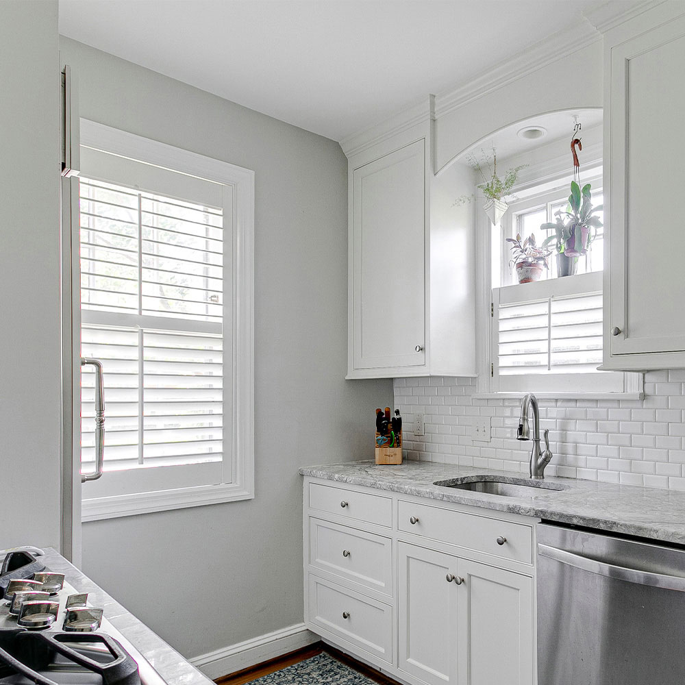 White shutters filtering sunlight in a bright kitchen